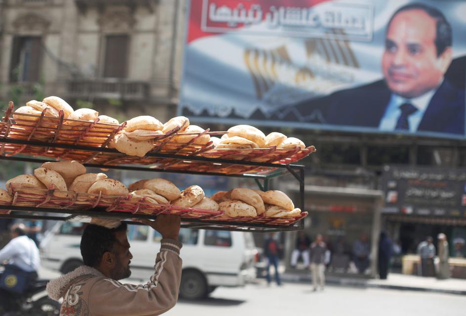 Egipat - čovjek nosi lepinje ispod postera predsjednika Sisija