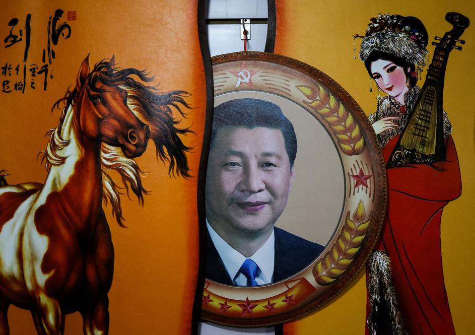 A portrait of Chinese President Xi Jinping seen next to traditional paintings in Hohhot