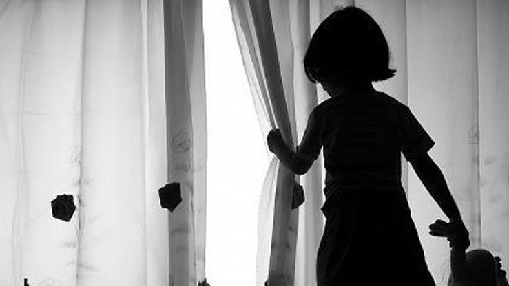 Djevojčica gleda kroz zavjesu