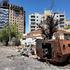FILE PHOTO: Members of army walks next to destroyed military vehicle and bombed buildings in the state of Khartoum