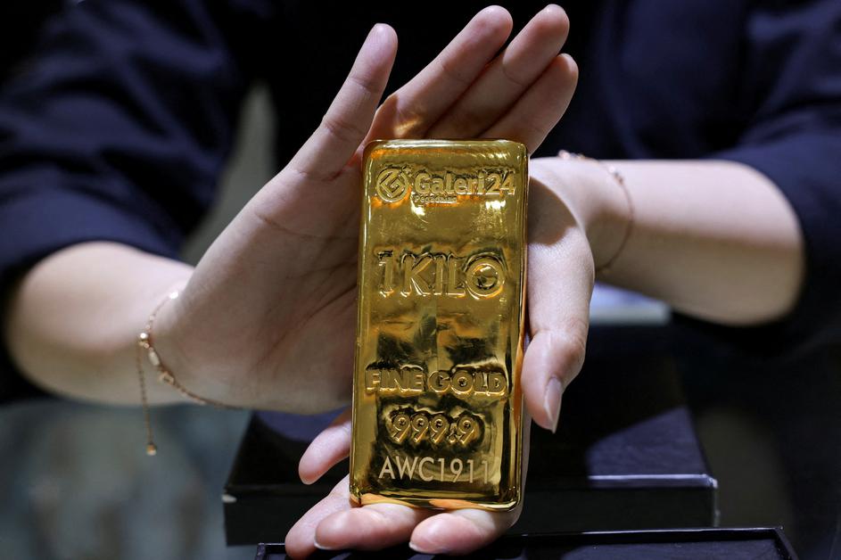 FILE PHOTO: A staff member shows a one kilogram gold bar at the Galeri 24 gold and jewellery shop in Jakarta