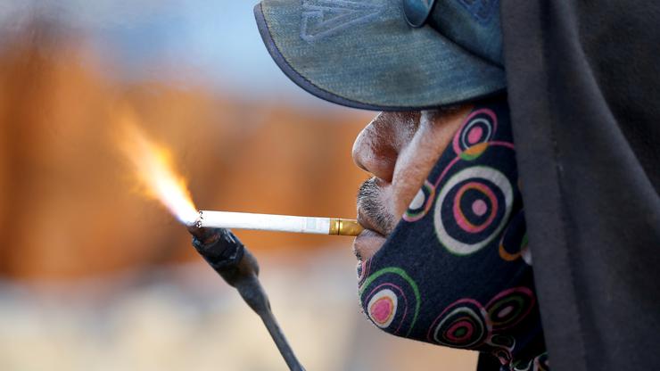 Radnik pali cigaretu plamenikom