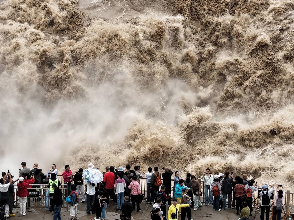 YAN AN, CHINA - SEPTEMBER 20: Tourists visit the Hukou Waterfall on the Yellow River as water volume significantly incre