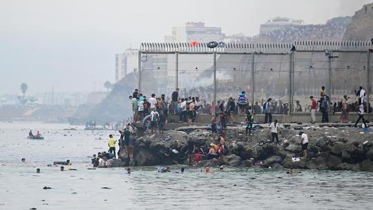 Migrants cross the border swimming through the sea, in Ceuta