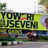 Motorcycle taxi passes Museveni campaign billboard ahead of Uganda election, in Kampala