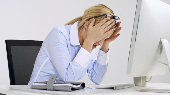 Umorna žena na poslu s glavoboljom
