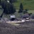 A few remaining houses are seen after a massive rock and ice slide covered most of the village of Blatten