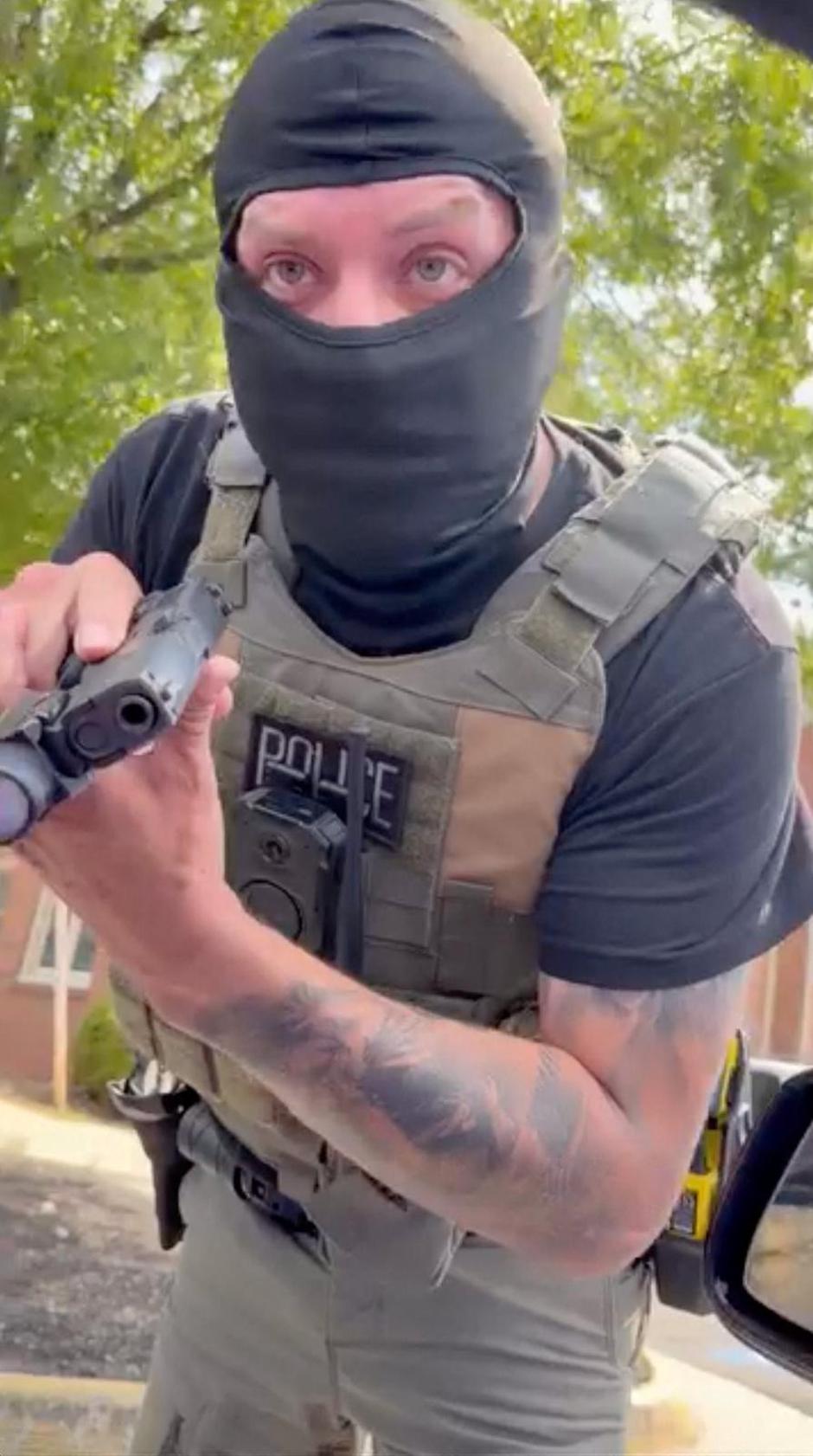 An ICE agent points a gun at Carolina Molina while she sits inside a vehicle, in Falls Church | Author: CAROLINA MOLINA/REUTERS