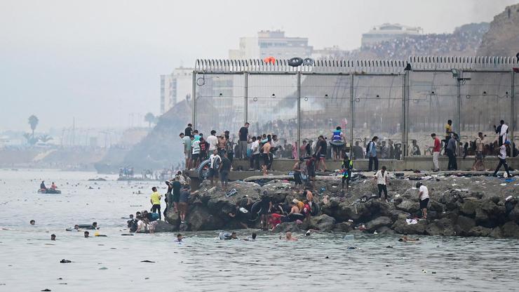 Migrants cross the border swimming through the sea, in Ceuta
