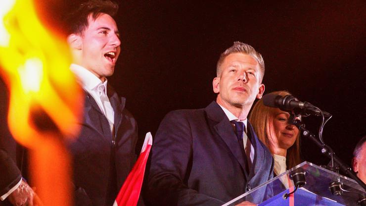 With lit torches flickering in the foreground, new Prime Minister of Hungary Peter Magyar delivers his victory speech. On the evening of April 12th, the day of the Hungarian parliamentary elections, supporters of the Tisza political party gather at Batthy