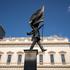Banksy Confirms latest artwork In Waterloo Place, Westminster, England, United Kingdom Tourists gather underneath the satirical statue, which depicts a man marching off a precipice while blinded by a massive flag, which has appeared outside the Athenaeum
