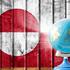 Globe with a world map on a wooden background with the image of the flag of Greenland. The concept of travel and leisure abroad.