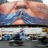 FILE PHOTO: People drive past an anti-U.S. billboard depicting U.S. President Donald Trump and the Strait of Hormuz, in Tehran