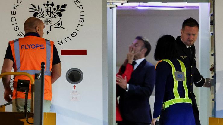 Macron's face appears to be shoved by wife in Vietnam