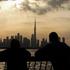 FILE PHOTO: People way the sunset over Dubai, with a general view of the Dubai skyline, including Burj Khalifa, center, amid the U.S.-Israel conflict with Iran