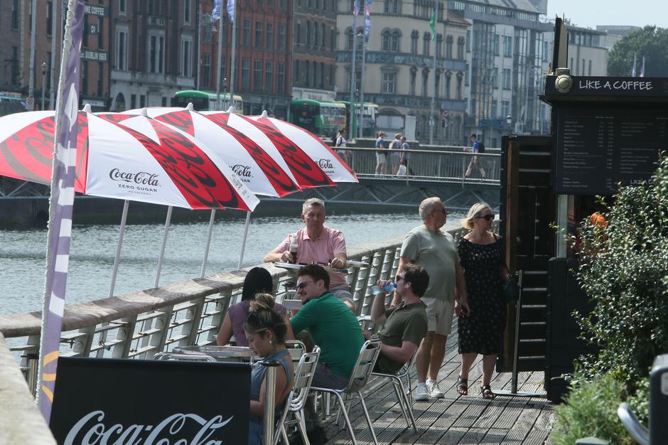 Dublin, Ireland  -  13th August 2025 - An outdoor coffee dock with seating and parasols on the Boardwalk along the River Liffey in Dublin city centre as the Irish capital experiences high temperatures and humidity | Author: Profimedia
