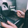 Hand of young woman inserting credit card into cash machine