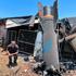 A man poses next to apparent remains of a ballistic missile following missile attack by Iran on Israel