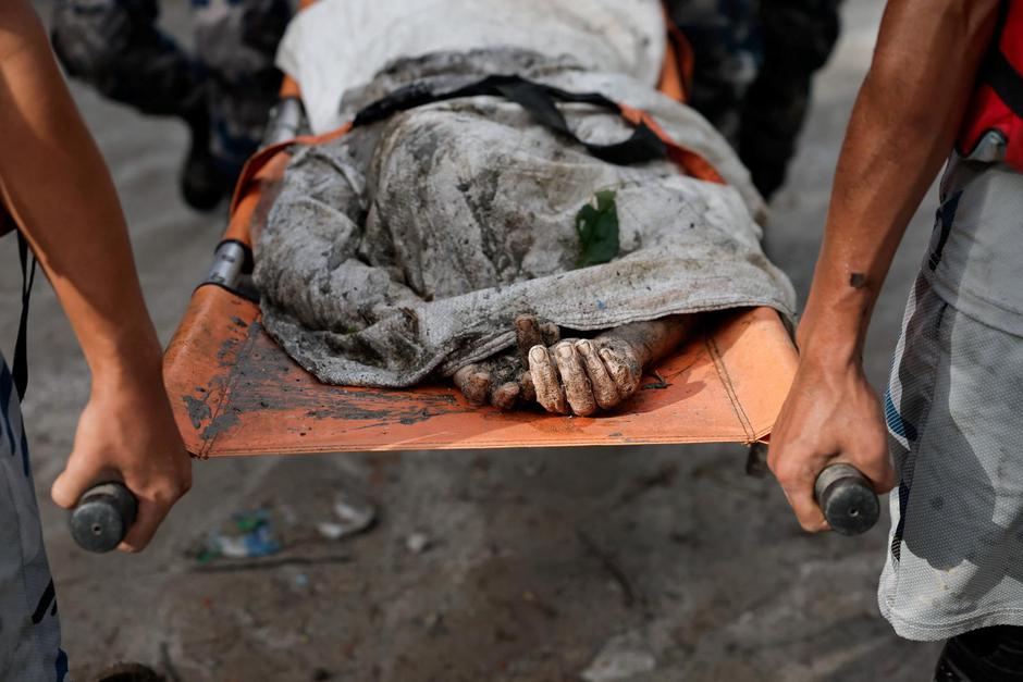 Members of a rescue team carry the body of a victim following devastating floods, in Trishuli | Author: NAVESH CHITRAKAR/REUTERS