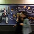 People walk past a sign with a picture depicting injured U.S. President Donald Trump, in Tehran