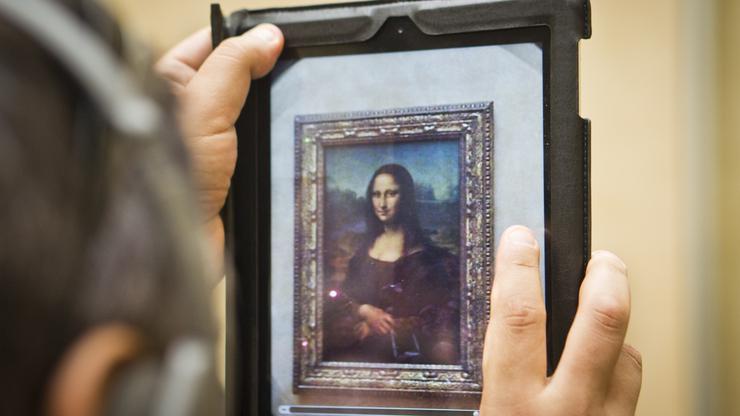 Turist u Louvreu slika Mona Lisu
