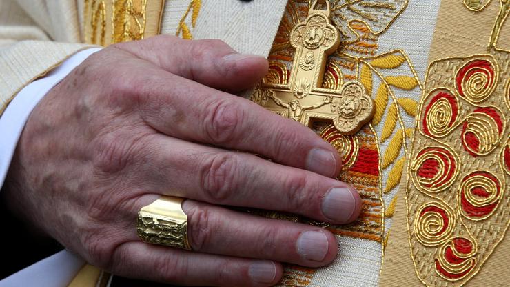 Kardinalova ruka na zlatnom križu