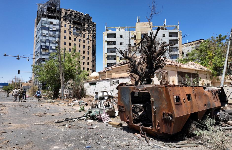 FILE PHOTO: Members of army walks next to destroyed military vehicle and bombed buildings in the state of Khartoum | Author: El Tayeb Siddig