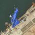 A satellite image shows a North Korean warship covered with a blue tarp after an accident that occurred during its launch at the shipyard in Chongjin