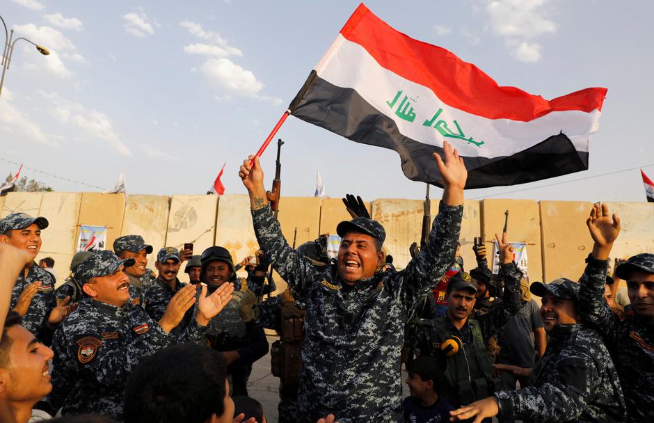 FILE PHOTO: A member of Iraqi Federal Police waves an Iraqi flag as they celebrate victory of military operations against the Islamic State militants in West Mosul | Author: Erik De Castro