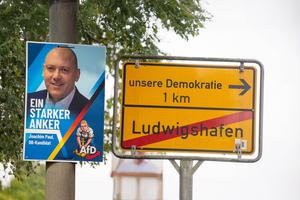(Fotomontage) Plakat des ausgeschlossenen Ludwigshafener Bürgermeisterkandidaten Joachim Paul (AfD), daneben ein Ortsaus