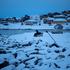 A man sits on a bench by the sea at Nuuk's old harbour